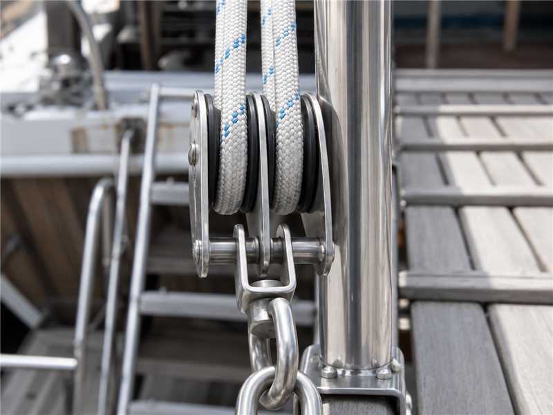 Stainless steel block and pulley rigged with rope on a sailboat mast