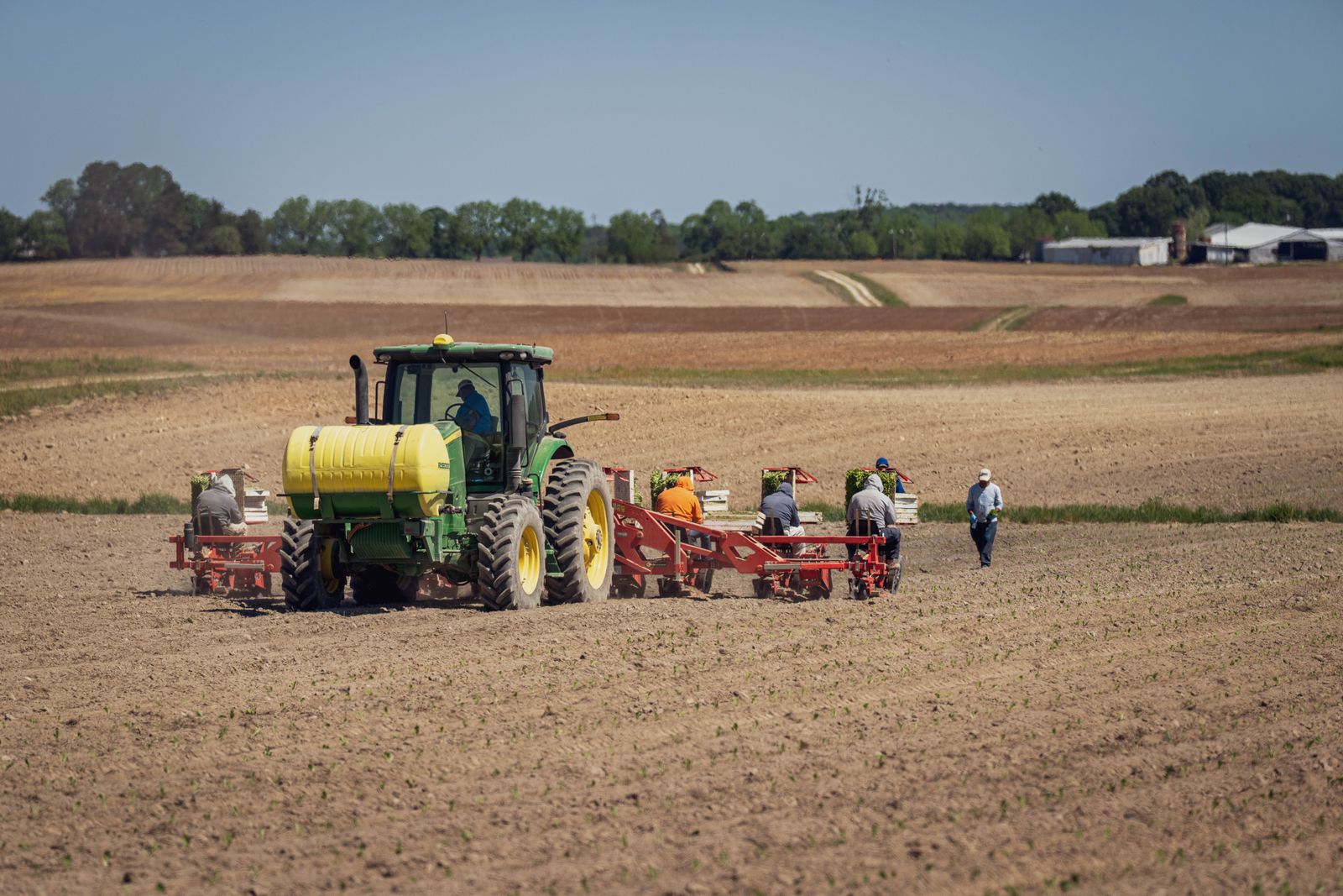 Tractor towing a planting rig across a field