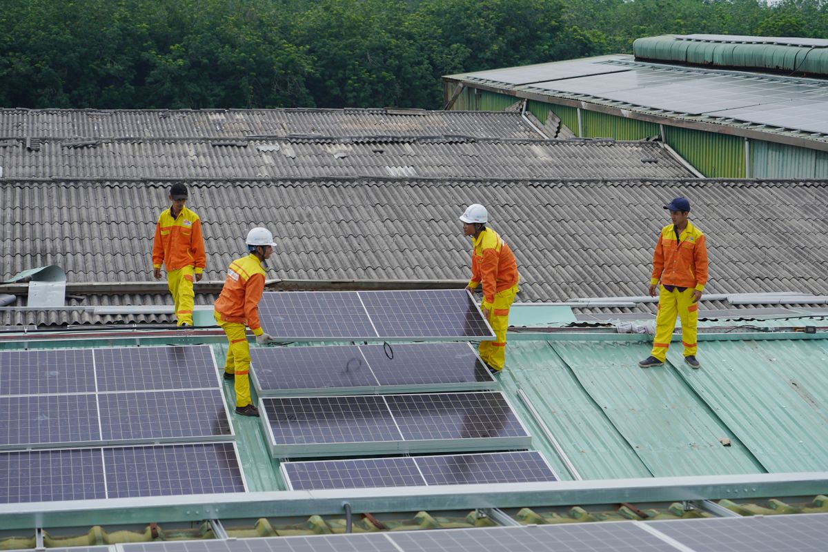 Crew installing solar panels on a commercial roof